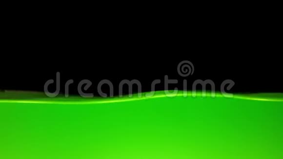 明亮的绿色水在黑色的背景上摇动视频的预览图