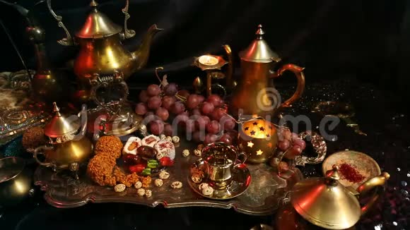 女性手与东方珠宝制作茶杯传统的摩洛哥糖果萨弗龙马萨拉奶茶杯视频的预览图