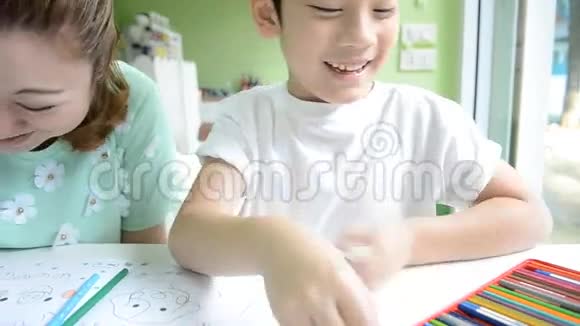 亚洲妈妈正在画她的儿子做学校的作业视频的预览图