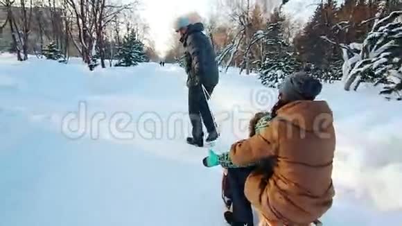 父亲带着母亲和儿子拉雪橇视频的预览图