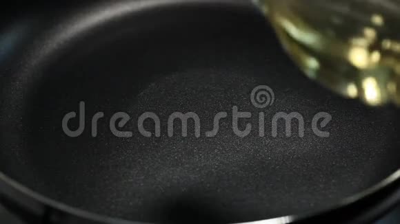 植物油从瓶子里倒在热锅上视频的预览图
