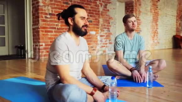 有水的男人躺在健身房的瑜伽垫上视频的预览图
