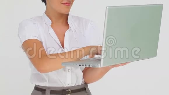 女商人拿着一台笔记本电脑打字视频的预览图