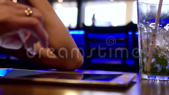 年轻女商人在酒吧休息饮料鸡尾酒使用平板电脑模糊的Bokeh背景视频的预览图