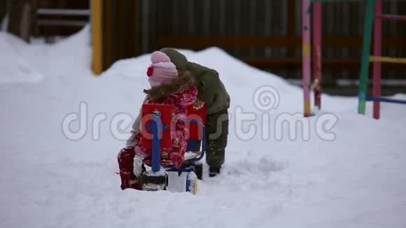 冬天一个女孩和一个男孩在外面玩视频的预览图