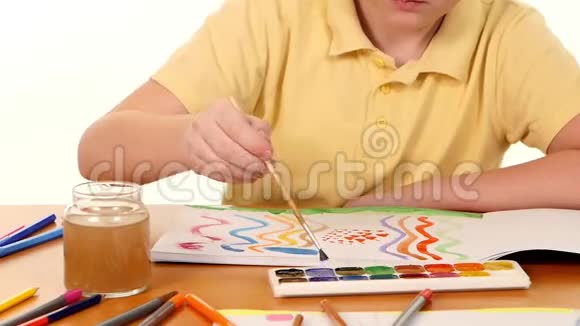 坐在桌子旁的小男孩在上面画颜色视频的预览图