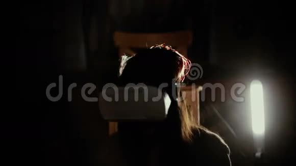 女人在聚光灯下使用VR头盔视频的预览图