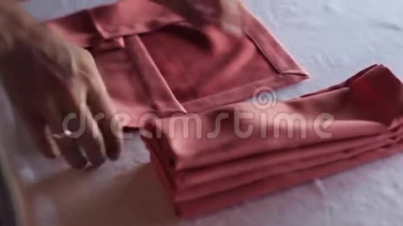 女人的手在桌子上转动红色的纺织餐巾视频的预览图