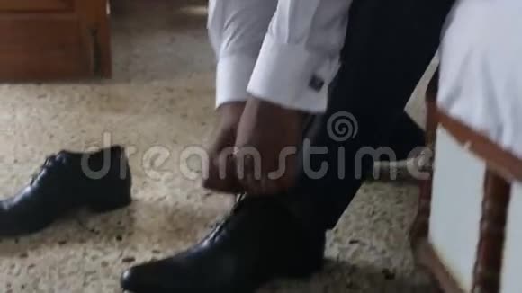 穿白色结婚衫的男人穿上黑色鞋子领带鞋带视频的预览图