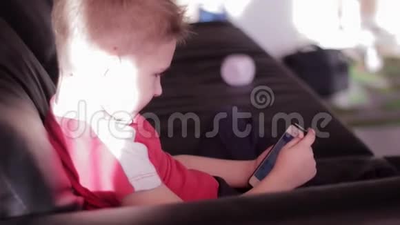 在家玩智能手机的小男孩视频的预览图