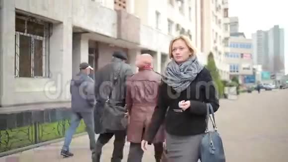 穿着暖和的衣服和围巾的女人走在街上视频的预览图