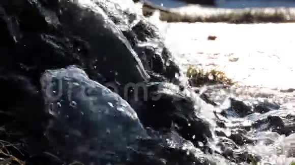 山瀑小溪河流阳光下的石头上溅起水花视频的预览图