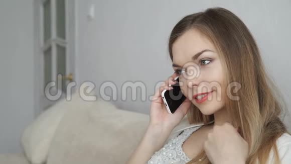 家庭技术和互联网概念微笑的女人坐在沙发上家里有智能手机视频的预览图