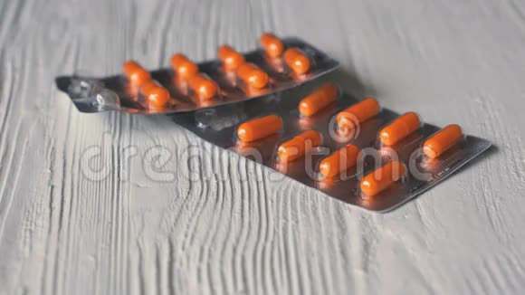 橙色胶囊中的药片落在白色的桌子上视频的预览图