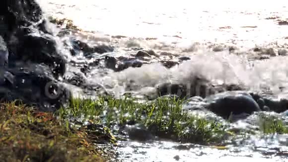 山瀑小溪河流阳光下的石头上溅起水花视频的预览图