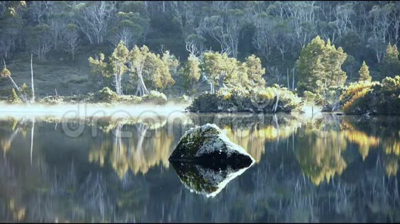 清晨的薄雾平静的湖面上有岩石视频的预览图