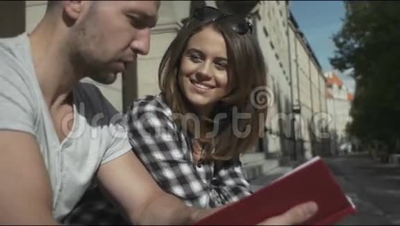 年轻夫妇一起读书坐在大学楼梯上户外视频的预览图