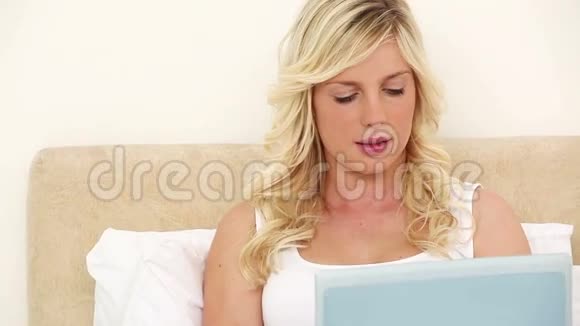 嘲笑金发女人用笔记本电脑视频的预览图