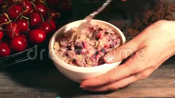 燕麦粥和樱桃黑色背景早餐麦片视频的预览图