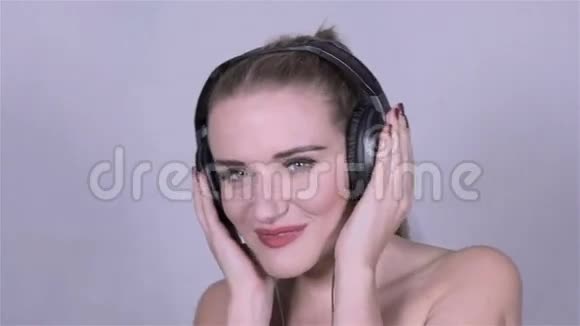 可爱的高加索女人带着耳机听音乐慢动作视频的预览图