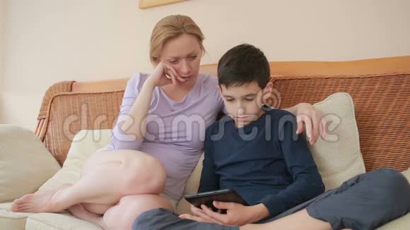 妈妈和她的儿子说得很好看着平板电脑触摸触摸屏视频的预览图
