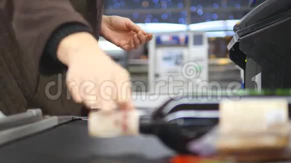顾客在结帐时支付产品费用超市传送带上的食物带收银机和终端机的现金台视频的预览图