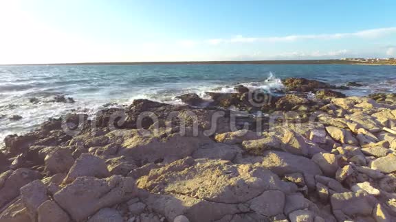 岸边的岩石日落时溅起浪花视频的预览图