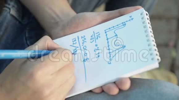 人手在纸笔记本图表上用蓝色记号笔画出数学任务夏季视频的预览图