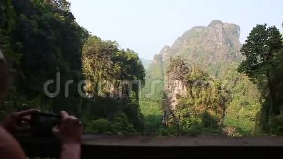 女人的后景拍摄丛林峡谷悬崖的照片视频的预览图