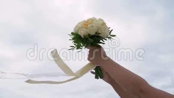 年轻的新娘穿着婚纱在公园里捧着花束白色豪华礼服视频的预览图