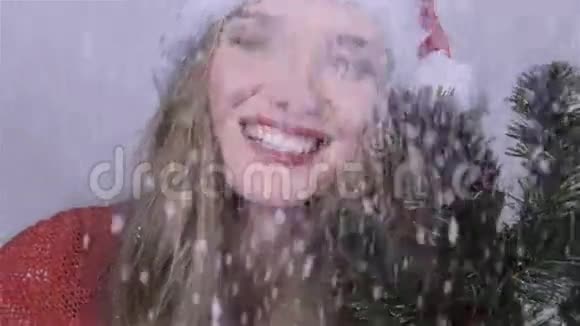 戴着圣诞老人帽子的女孩树枝在享受降雪视频的预览图