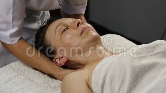 女性医生为客户做抗衰按摩女人在SpaSaton享受塑料面部按摩慢动作视频的预览图