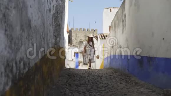 在欧洲老城区狭窄的街道上行走的女人视频的预览图