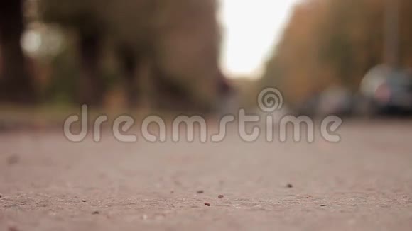 男子推滑板在沥青路低角度射击滑冰运动员移动到相机并急剧停止视频的预览图
