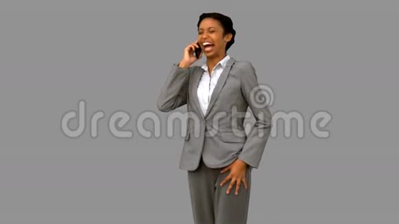 快乐的女商人一边笑一边打电话给灰色屏幕视频的预览图