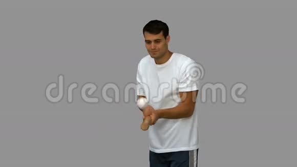 带着棒球在灰色屏幕上运球的人视频的预览图