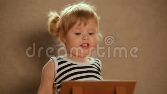 小女孩在平板电脑上玩视频的预览图