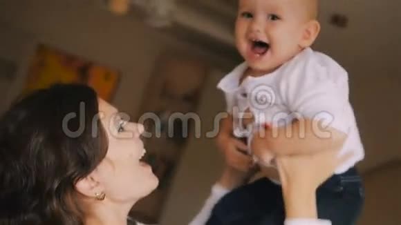 年轻的快乐母亲抱着她的新生儿吐了出来家里的家人美丽的微笑妈妈和快乐的宝贝视频的预览图
