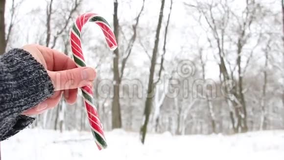 手里拿着糖果拐杖圣诞风景视频的预览图