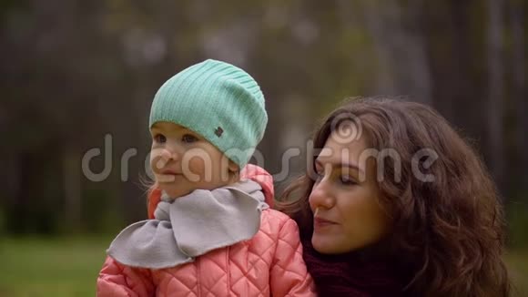 秋天公园里有个孩子的美丽年轻女人的肖像两个年轻母女的肖像慢慢慢慢视频的预览图