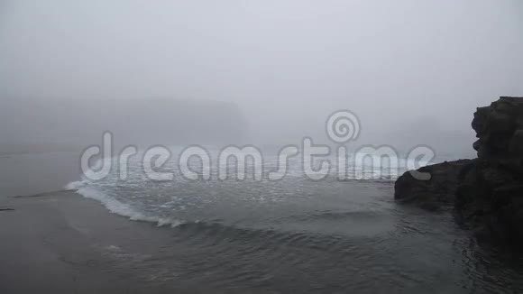 大岩石之间的波浪雾笼罩着大海视频的预览图