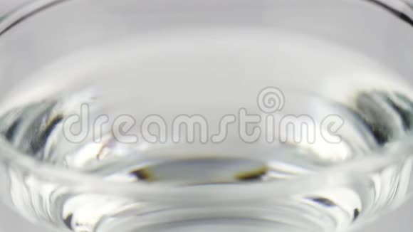 黄色泡腾片止痛片落入玻璃杯中在彩色片上溶解慢镜头的阿司匹林视频的预览图