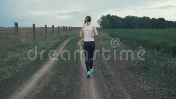 田径场上跑马路的运动女孩户外健身用安定剂射击视频的预览图