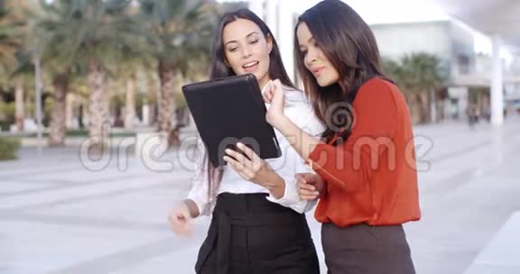 在户外看平板电脑的年轻女子视频的预览图