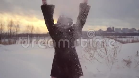 快乐快乐的美丽女人在户外玩在冬天在日落时慢动作地扔雪1920x1080视频的预览图