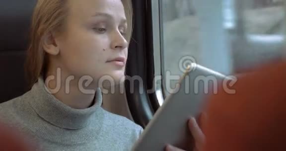 带着平板的微笑女人在火车上视频的预览图