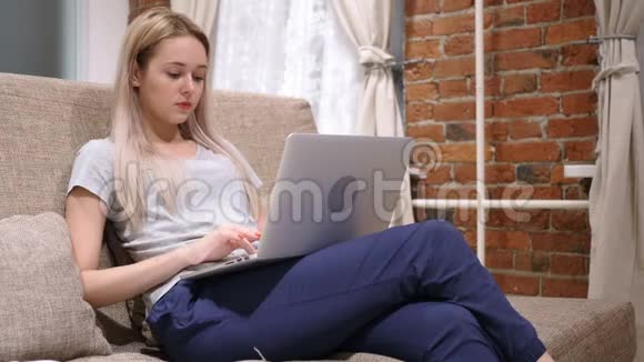 晚上在笔记本电脑上工作的年轻女子视频的预览图