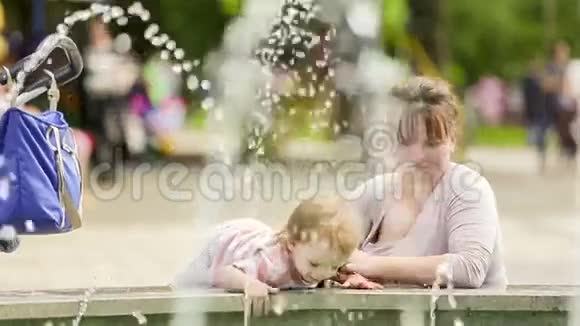 母亲和婴儿在公园享受喷泉视频的预览图
