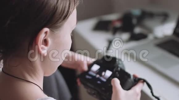 女摄影师在她的相机上看照片视频的预览图