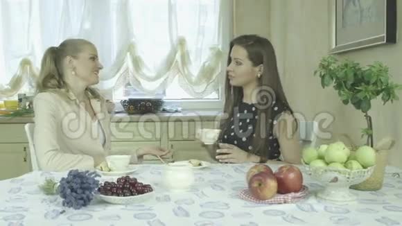 两位优雅迷人的微笑的年轻女士在餐桌上喝咖啡视频的预览图